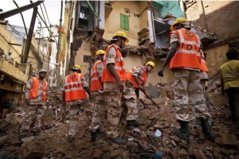 Rescue workers search the rubble at the site of a building collapse in the old quarters of New Delhi. Kevin Frayer / AP Photo