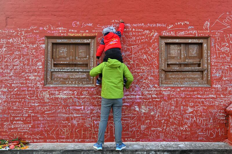 A message is chalked on to a wall at Saraswati temple, where worshippers are marking the Hindu festival of 'Basanta Panchami', in Kathmandu. AFP