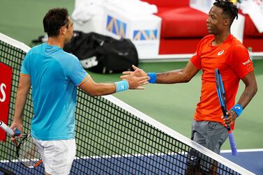 Gael Monfils, right, greets Marcos Baghdatis at the net following their second round match in Dubai. EPA