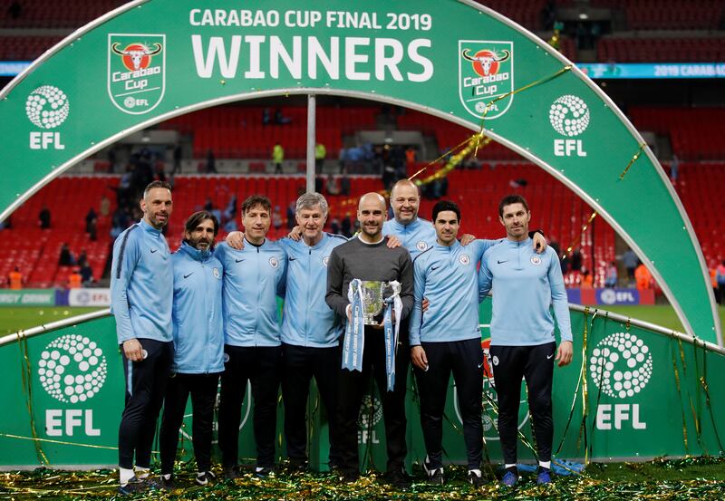 Pep Guardiola and his coaching staff pose with the League Cup in 2019. Reuters