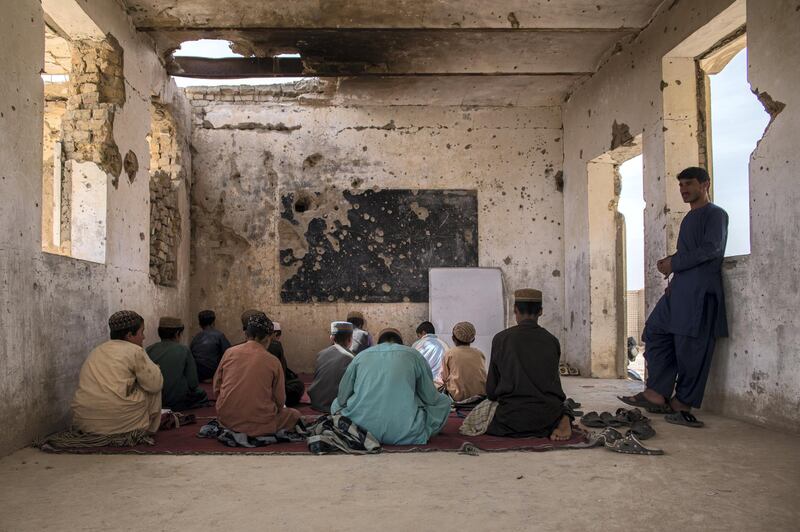 Students sit in their classroom at Assad Suri Primary School in Kandahar's Zhari District. Many of the buildings have been destroyed in airstrikes and by blasts, leaving classrooms exposed and bullet riddled. Part of the school continues to be occupied by the local police. 