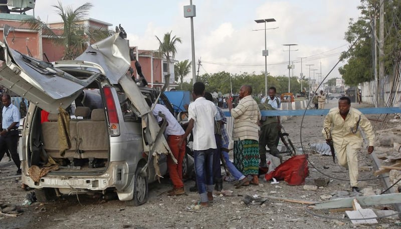 A Somali policeman runs through the wreckage outside the Sahafi Hotel in Mogadishu, Somalia, on November 1, 2015. Farah Abdi Warsameh / Associated Press