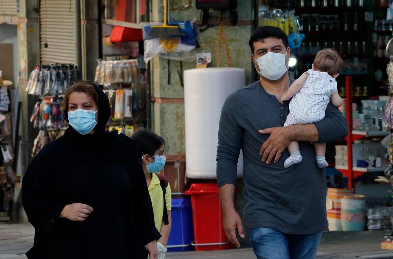 Iranians walk past in a street, in Tehran. EPA