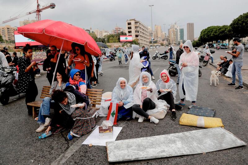 Lebanese protester have lunch together on a blocked avenue in the centre of the capital Beirut during ongoing anti-government demonstrations. AFP