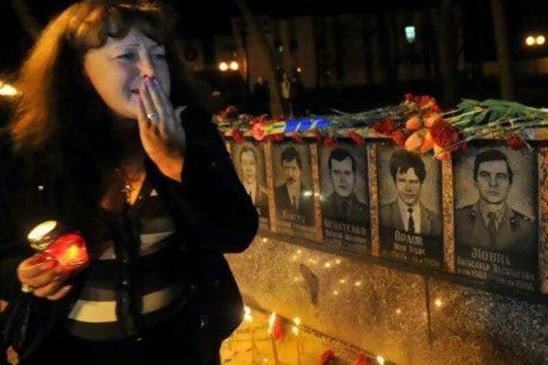 A woman cries before the monument to Chernobyl victims in Slavutich, where many of the plant's former staff were relocated.