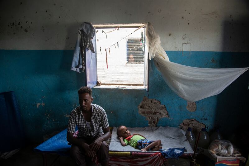 Abdualha, 28, sits in a shelter with his sick son at the camp in Sudan. ‘I left Eritrea last May to come to Sudan, looking for hope of a better life. My son needs an operation on his brain and I'm not able to find a doctor for him until now,’ he says. Getty