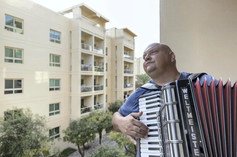 Dubai, United Arab Emirates - Reporter: Rory Reynolds: Boki Prekovic, a Serbian accordion player keeping residents stuck at home entertained from his balcony. Thursday, March 19th, 2020. The Greens, Dubai. Chris Whiteoak / The National