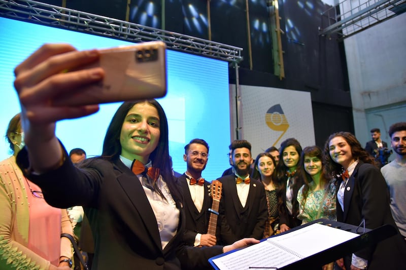 Musicians of the Watar orchestra take a selfie at the concert. EPA