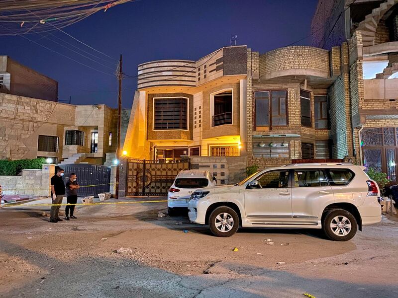Iraqi police officers investigate the scene outside Husham Al Hashimi's house after he was shot dead in Baghdad on Monday following threats from Iran-backed militias. AP