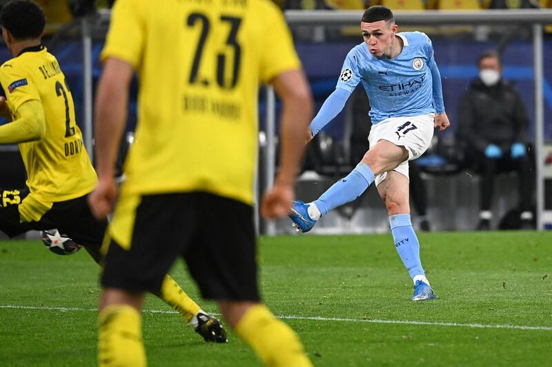 Manchester City's English midfielder Phil Foden (R) scores the 1-2 goal during the UEFA Champions League quarter-final second leg football match between BVB Borussia Dortmund and Manchester City in Dortmund, western Germany, on April 14, 2021. (Photo by Ina Fassbender / various sources / AFP)