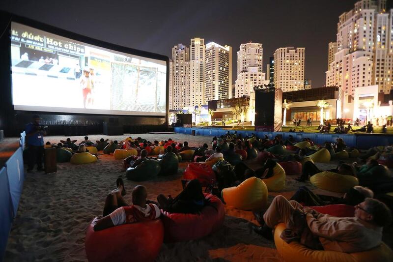 People watching a movie at the beach opposite Jumeirah Beach Residence in Dubai. Pawan Singh / The National