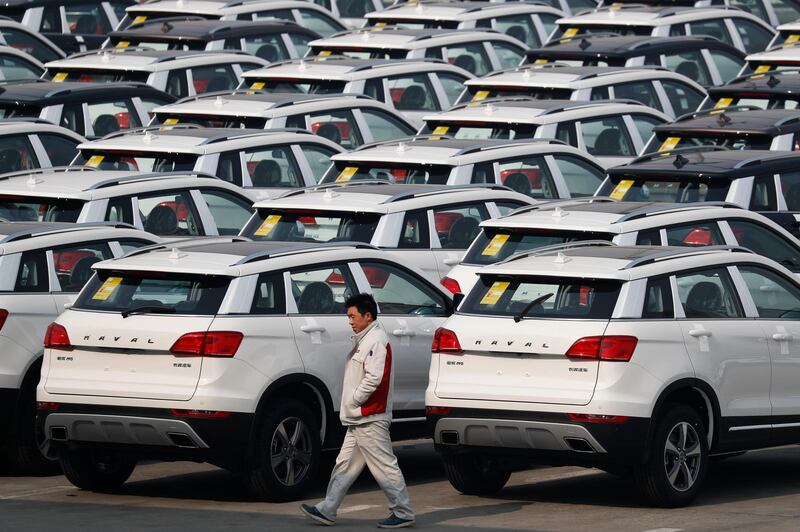 FILE - In this Feb. 19, 2017, file photo, a worker walks past Haval SUV models parked outside the Great Wall Motors assembly plant in Baoding in north China's Hebei province. Chinese SUV maker Great Wall Motors is considering making a bid to acquire Fiat Chrysler's Jeep unit, two employees of the Chinese company said Monday, Aug. 21, 2017 in an ambitious new move for the country's fast-growing domestic auto brands. Great Wall has yet to make a formal announcement of its interest in Jeep but a possible acquisition would be in line with chairman Wang Jianjun's goal, announced in February, of becoming the top specialty SUV producer by 2020. (AP Photo/Andy Wong, File)