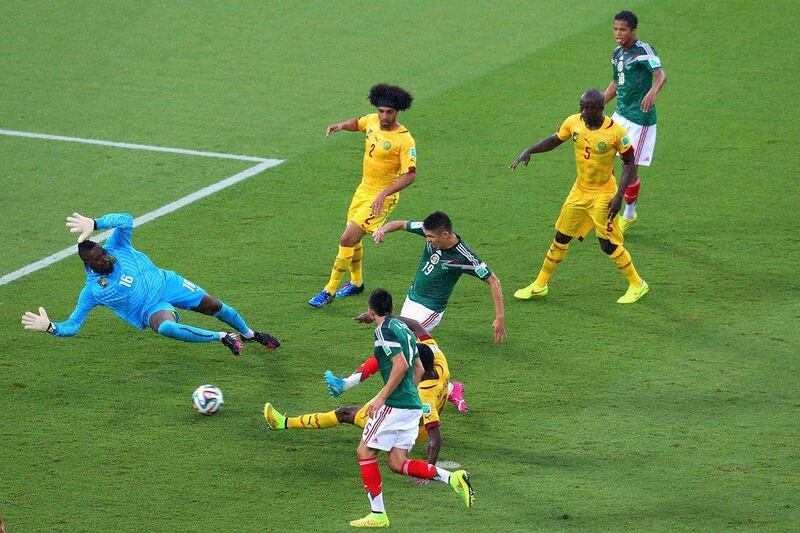 Oribe Peralta of Mexico (No 19, middle), shoots to score the one goal in Mexico's 1-0 win over Cameroon on Friday past Cameroon goalie Charles Itandje in Natal, Brazil. Miguel Tovar / Getty Images