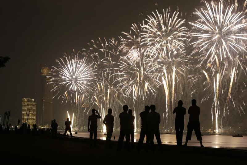 People watch the National Day fireworks along the Corniche in Abu Dhabi. Silvia Razgova / The National