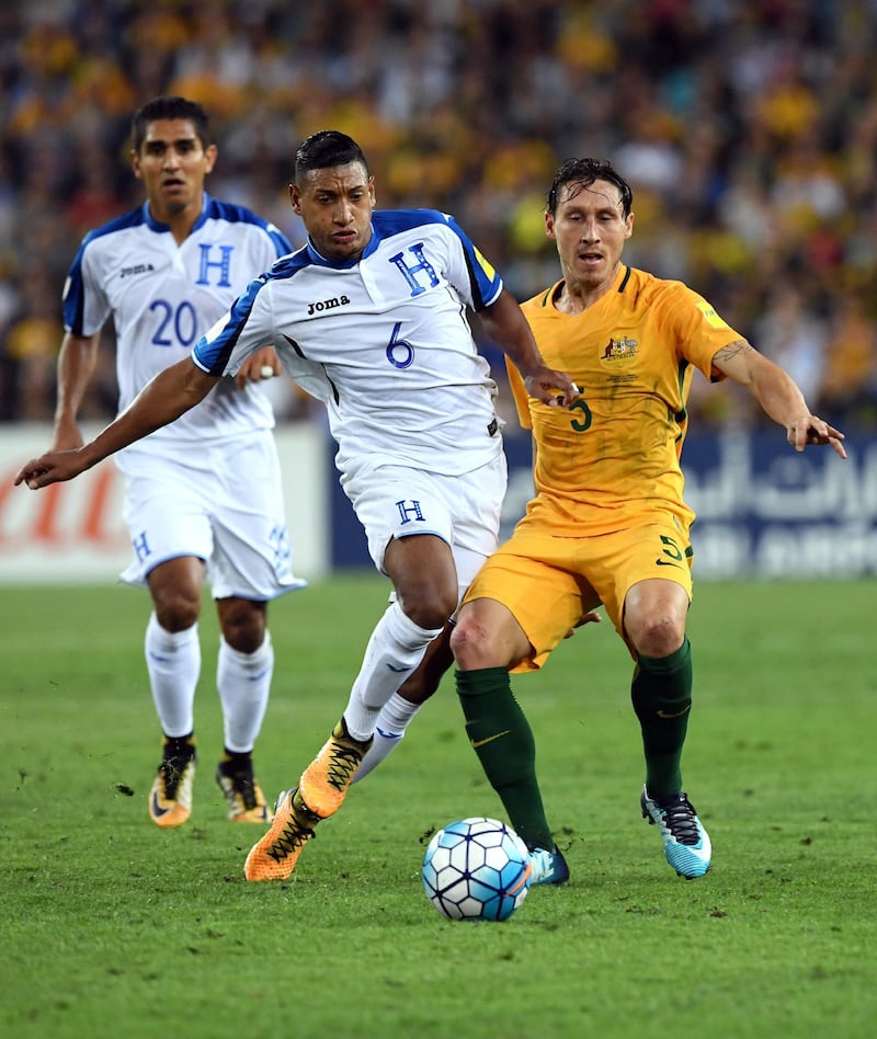 Australia's Mark Milligan (R) is tackled by Honduras' Brayan Acosta (L) as Jorge Claros (L) looks on during their 2018 World Cup qualification play-off football match against at Stadium Australia in Sydney on November 15, 2017. / AFP PHOTO / William WEST / -- IMAGE RESTRICTED TO EDITORIAL USE - STRICTLY NO COMMERCIAL USE --