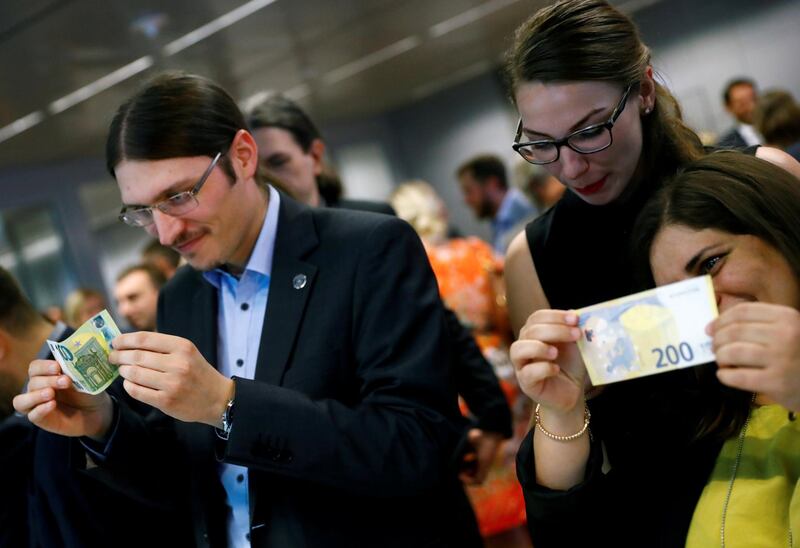 FILE PHOTO: People hold new 100- and 200-euro banknotes during a presentation at the ECB headquarters in Frankfurt, Germany, September 17, 2018. REUTERS/Kai Pfaffenbach/File Photo