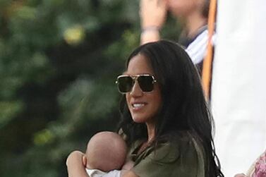 Britain's Meghan, Duchess of Sussex holding her son Archie, at the Royal Charity Polo Day at Billingbear Polo Club, Wokingham, England, Wednesday, July 10, 2019. (Andrew Matthews/PA via AP)