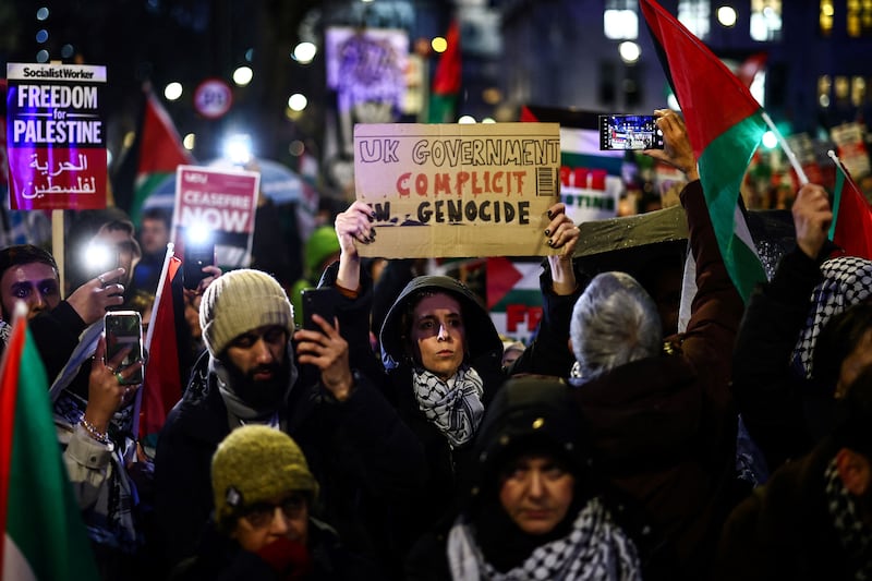 Demonstrators wave Palestinian flags and hold placards in Parliament Square. AFP