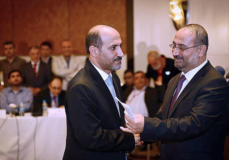 Ahmad Tuma, right, the Syrian National Coalition interim prime minister, shakes hand with the chief of SNC, Ahmad Jarba after a press conference on Sunday in Istanbul. SNC Media Office / HO / AFP