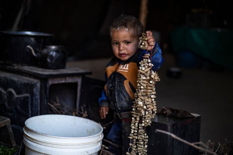 A child holds dried okra at the Kabsh camp for displaced people in the countryside near Raqa. AFP