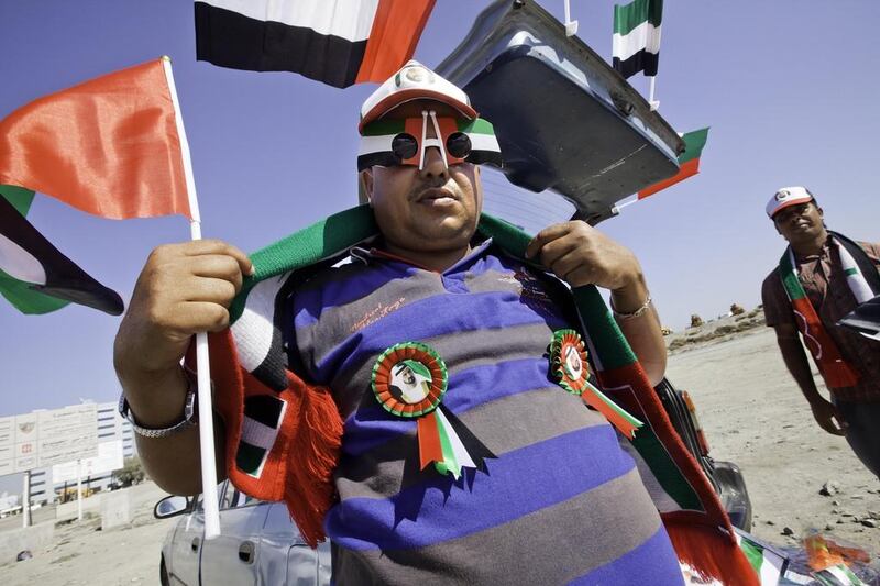 Two enterprising traders set up a stall from the boot of their car to sell National Day flags, scarves and rosettes in Fujairah – and business was booming all day long. Jaime Puebla / The National