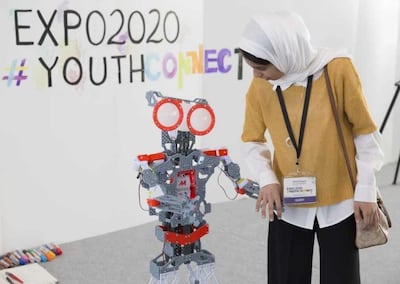 Fatima Al Kaabi poses with a robot as part of a project she worked on at an event organised by Expo 2020. Handout