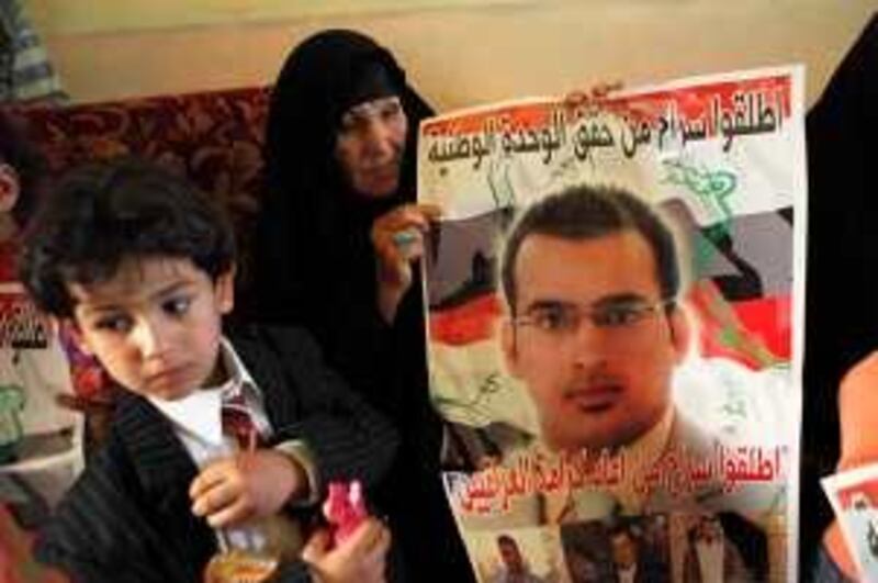 A relative of the Iraqi journalist Muntadhar al-Zeidi who threw shoes at then-President George W. Bush holds up a poster in support of the journalist at his home after he was convicted of assaulting a foreign leader and sentenced to three years in prison in Baghdad, Iraq, Thursday, March 12, 2009. The posters shows a portrait of Muntadhar al-Zeidi and reads: "Release he who achieved Iraqi unity", and at the below "Release he who restored Iraqi dignity". (AP Photo/Khalid Mohammed) *** Local Caption ***  BAG112_Iraq_Bush_Shoe.jpg