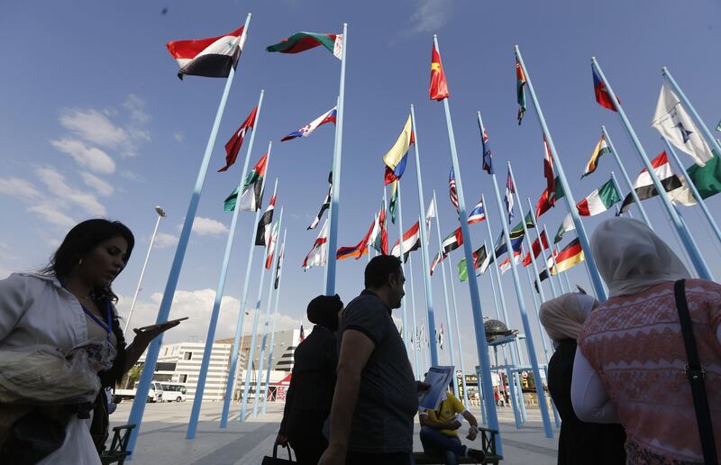 Visitors walk past flags as they arrive at the Damascus International Fair in the Syrian capital. AFP