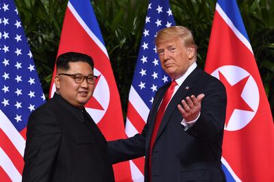 US President Donald Trump (R) gestures as he meets with North Korea's leader Kim Jong Un (L) at the start of their historic US-North Korea summit, at the Capella Hotel on Sentosa island in Singapore on June 12, 2018. Donald Trump and Kim Jong Un have become on June 12 the first sitting US and North Korean leaders to meet, shake hands and negotiate to end a decades-old nuclear stand-off. / AFP / SAUL LOEB
