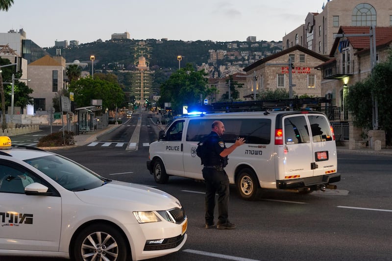 A policeman stops traffic to allow police cars to make their way towards reported rioting in Haifa, Israel, on Thursday. Jews and Arabs have been involved in mob violence. Daniel Rolider / Getty Images