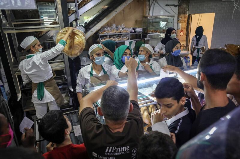 Workers wearing protective face masks serve a large crowd of customers at  a bakery in Beirut on June 27. Bloomberg