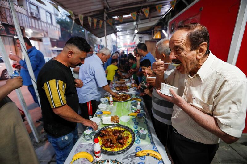 Iraqis tuck into their iftar meal in Baghdad's Adhamiya district, Iraq. Reuters