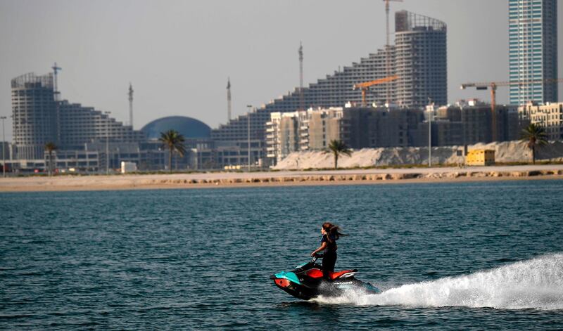 A woman rides a jet ski at al-Mamzar district in Dubai on May 14, 2020, as COVID-19 coronavirus pandemic lockdown measures are eased in the Gulf emirate.  / AFP / Karim SAHIB
