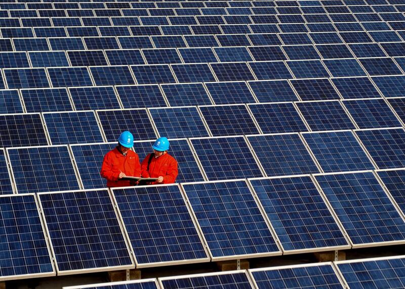 FILE - In this Feb. 7, 2012, file photo, workers check solar panels at a solar power station on a factory roof in Changxing in eastern China's Zhejiang province. One of China's biggest makers of solar panels said Tuesday, Feb. 6, 2018, that it will invest $309 million to expand manufacturing in India to guard against what it said is a rising threat of import controls in the United States and other markets. (Chinatopix via AP, File)