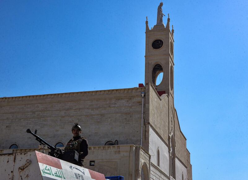 A fighter from the Nineveh Plain Protection Units, an Assyrian Christian militia, stands guard outside the Church of the Immaculate Conception in Qaraqosh. AFP
