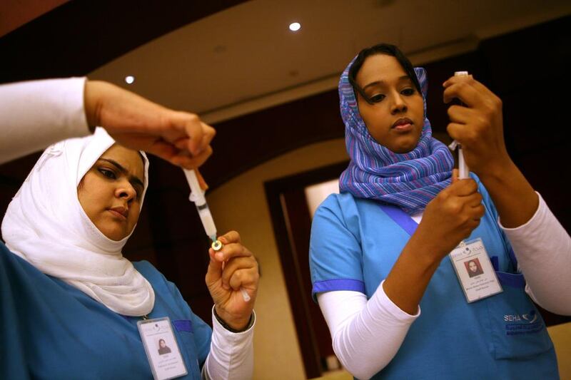 Nurses with Seha prepare flu vaccines. Experts have urged employers to have their staff vaccinated. Sammy Dallal / The National