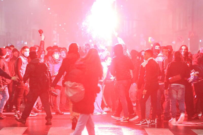 Protesters light a flare during clashes with police at Central Station in Milan. EPA