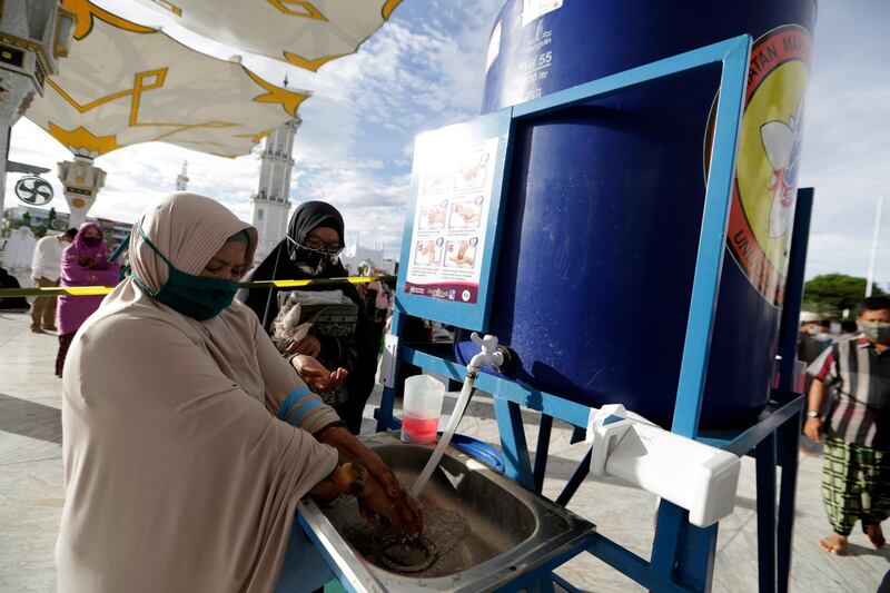 Muslim devotees wash their hand before attending Eid Al Adha prayers at Baiturrahman Grand Mosque, Banda Aceh, Indonesia. EPA