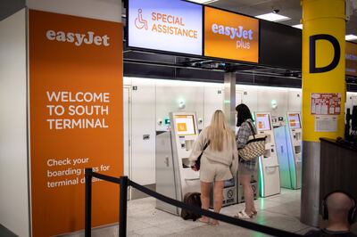 Travellers queue to check in for their EasyJet flights at Gatwick Airport in London. EPA