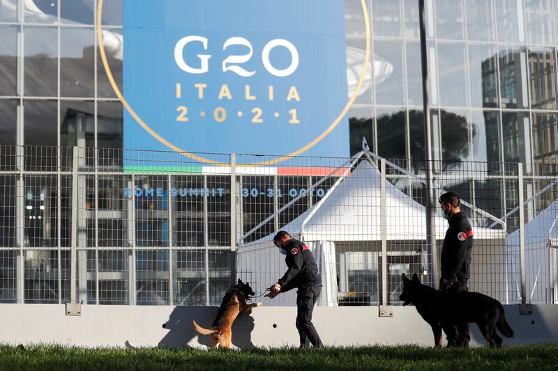 Carabinieri police officers inspect the area with explosive detection dogs outside La Nuvola. Reuters