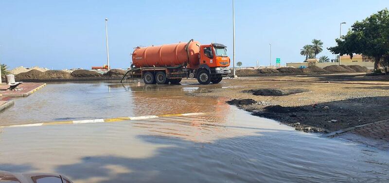 Municipality workers use a pump machine to drain a waterlogged road on Wednesday afternoon