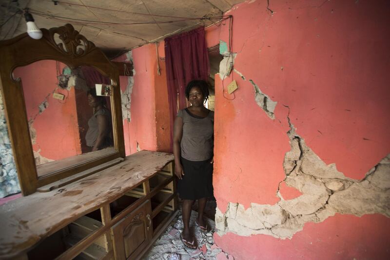 A woman walks amid the debris of her house that was destroyed in Gros Morne. EPA