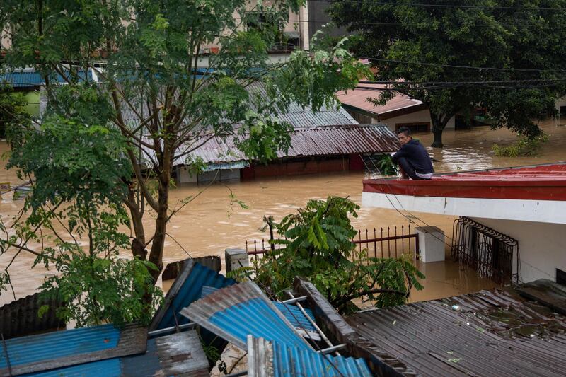 A man is pictured on top of a roof after floods caused by Typhoon Vamco, in San Mateo, Rizal province. Reuters