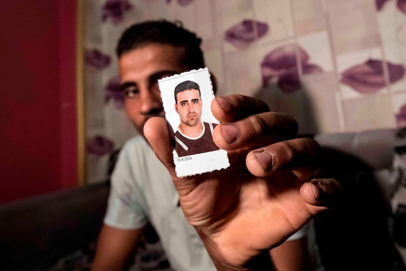 Egyptian Karim Farrag displays a picture of his brother Mohamed, one of 17 Egyptians that went missing in Libya while trying to get to Europe, during an interview at the Dahmasha village in the Sharkia governorate, 60Km northeast of the capital, on September 23, 2020. Thousands of desperate migrants bound for Europe have perished in the Mediterranean Sea. In one impoverished Egyptian town, families fear that 15 of their sons are among the dead. / AFP / Khaled DESOUKI
