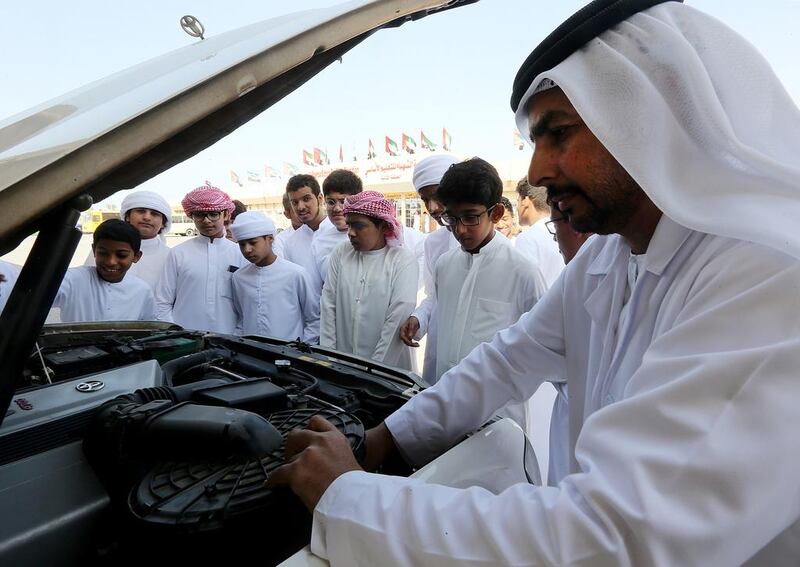 Social worker Yaqoob Mohammed Al Hammadi teaches  school students how to fix cars and  regular maintenance on as part of a behavioral correction  at a school in Sharjah. Satish Kumar / The National 