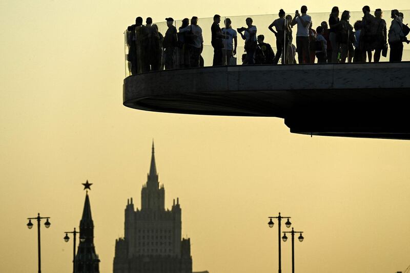 Visitors to Zaryadye park in front of the Russian Foreign Ministry headquarters enjoy a sunset in Moscow. AFP