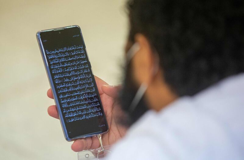 A pilgrim reads passages of the Quran from his phone. AFP
