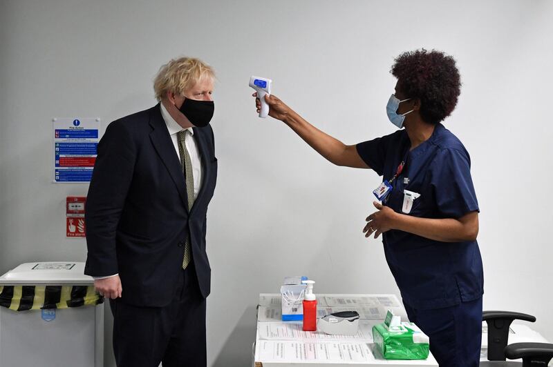Prime Minister Boris Johnson has his temperature checked during a visit to Chase Farm Hospital on the day that the NHS ramps up its vaccination programme. Getty Images