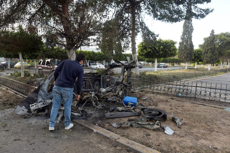 A man inspects the wreckage of a car outside the Khadra General Hospital in Tripoli.  AFP