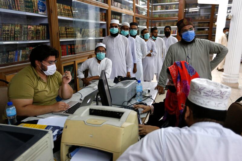 Patients queue to submit their details before they can receive a Covid-19 vaccine in Lahore. Associated Press